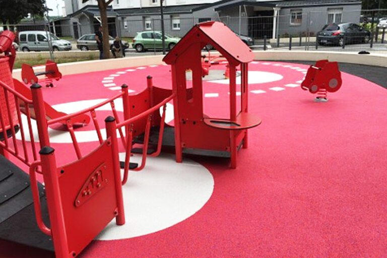 Play Flecks safety surfacing system shown installed on a playground. Red surface with red playground equipment.